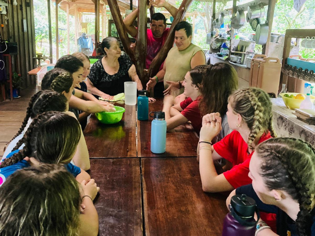 speaking with RAC hosts in rainforest table students around