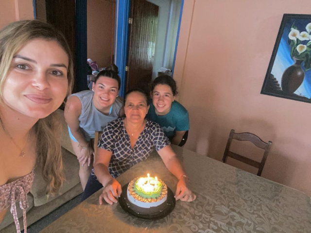 students with host family with a cake candles light