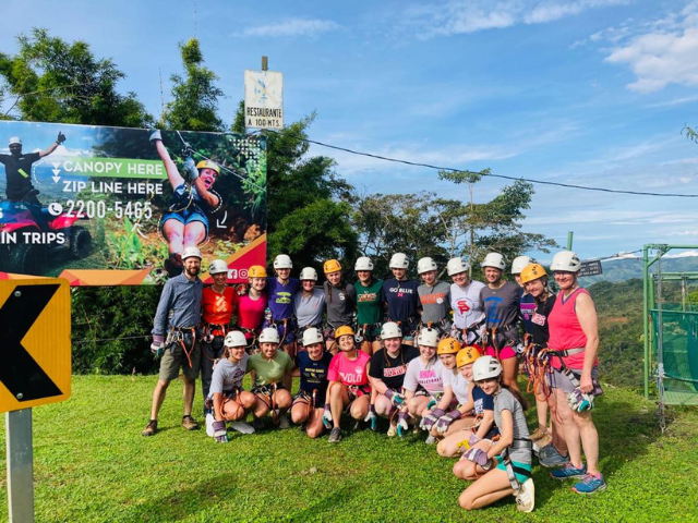 students in helmets in front of ziplining adventure
