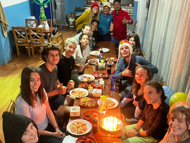 students sitting down for birthday dinner at candlelight