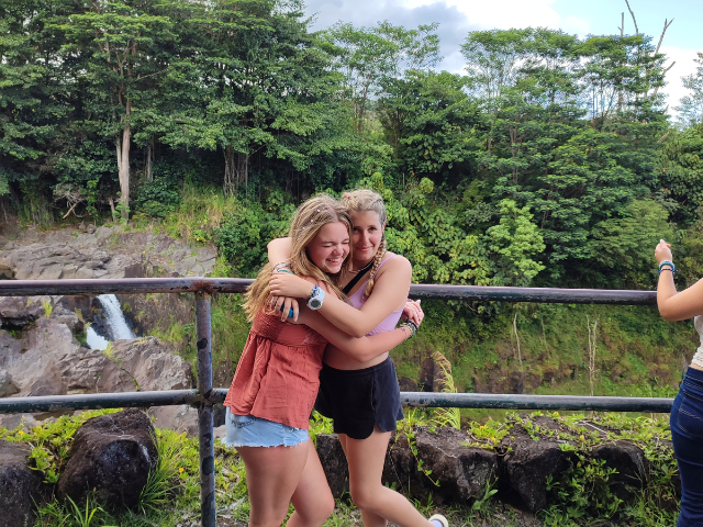 students hugging outside waterfall