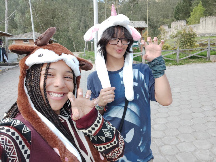students waving hats outside