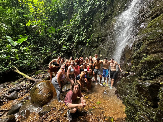 students bathing under waterfall
