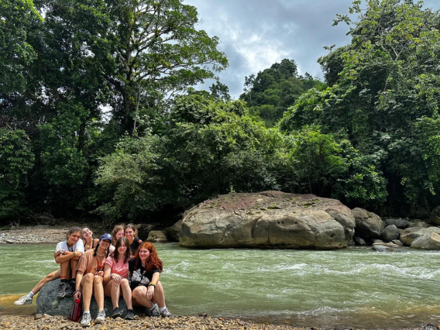 students on rock at river crossing
