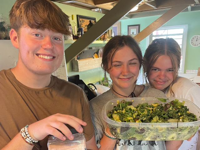 students making big salad meal time salt