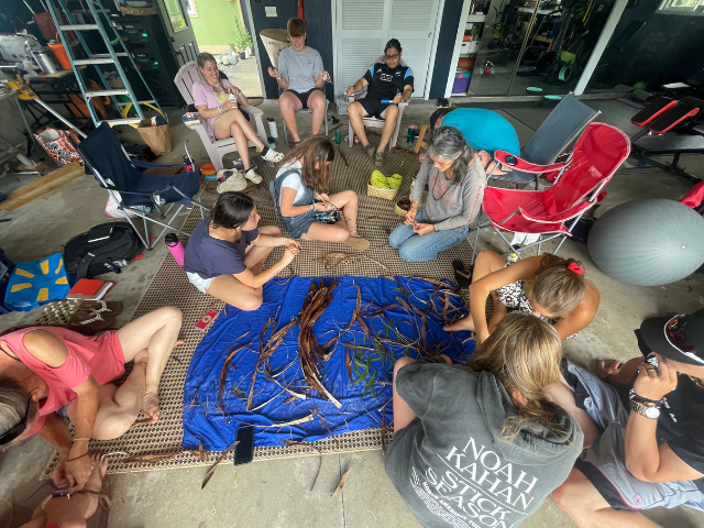 group practicing lei weaving