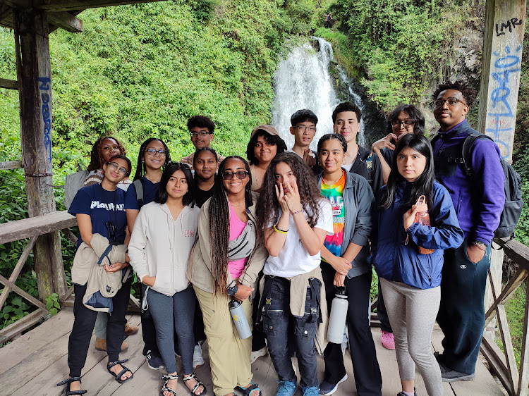 summer search students in front of a waterfall outside ecuador