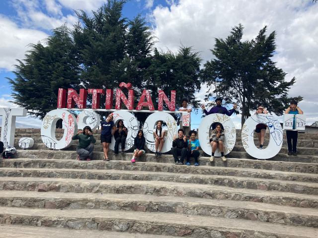 Students in Ecudor standing in front of sign