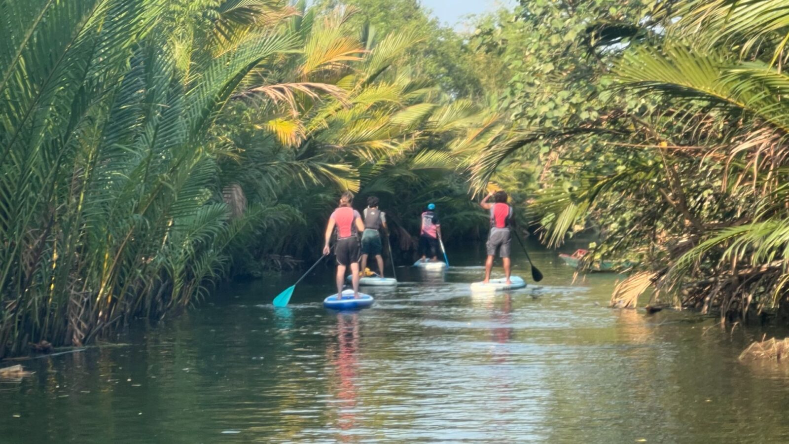 paddleboarding through river in Cambodia